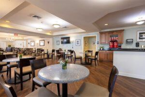 A modern dining area with several tables and chairs, featuring a clean and bright interior design.
