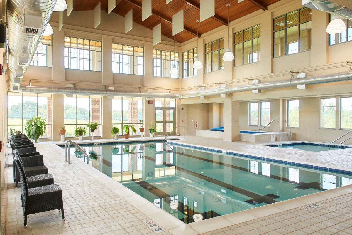 A spacious and well-lit indoor swimming pool with elegant architecture.