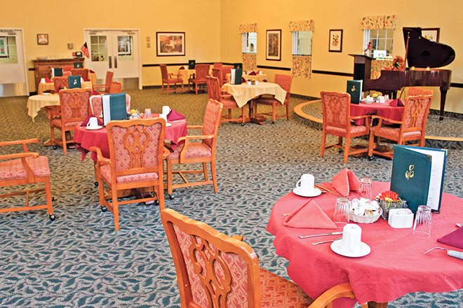 An elegant dining room with set tables and chairs, ready for guests.