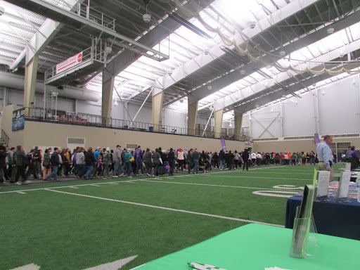 A crowd of people waiting in line inside a sports facility.