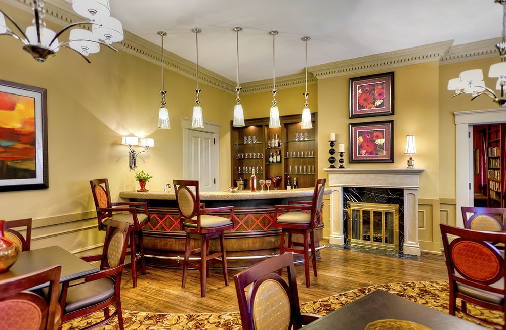 A stylish home bar setup with elegant furnishings and ambient lighting.
