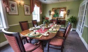 A beautifully set dining room with a wooden table and elegant decor.