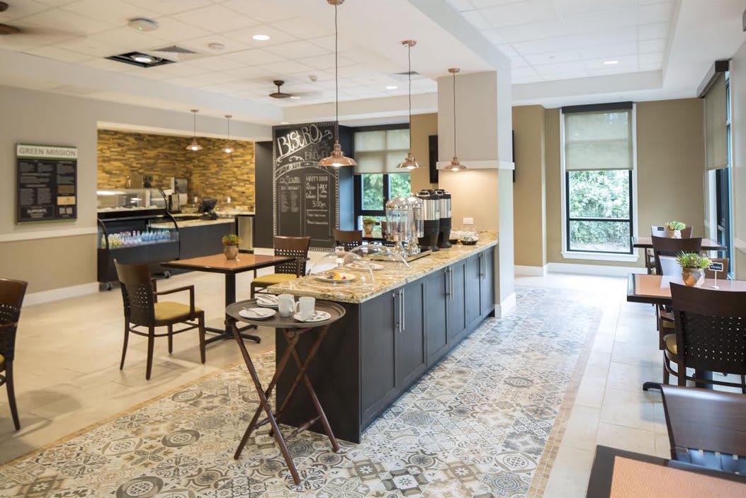 A modern kitchen with a sleek countertop, dining area, and stylish pendant lights.