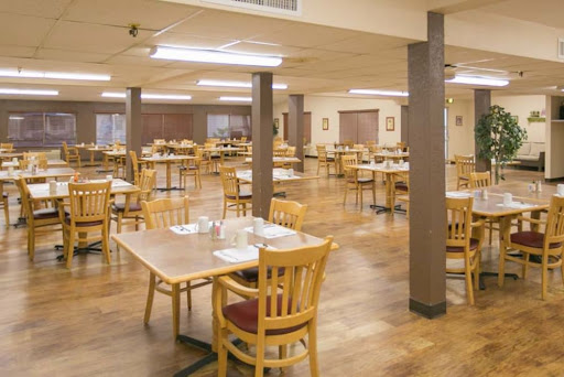A spacious dining area with wooden tables and chairs, awaiting guests.
