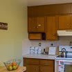 A cozy kitchen with wooden cabinets and a fruit bowl on the counter.