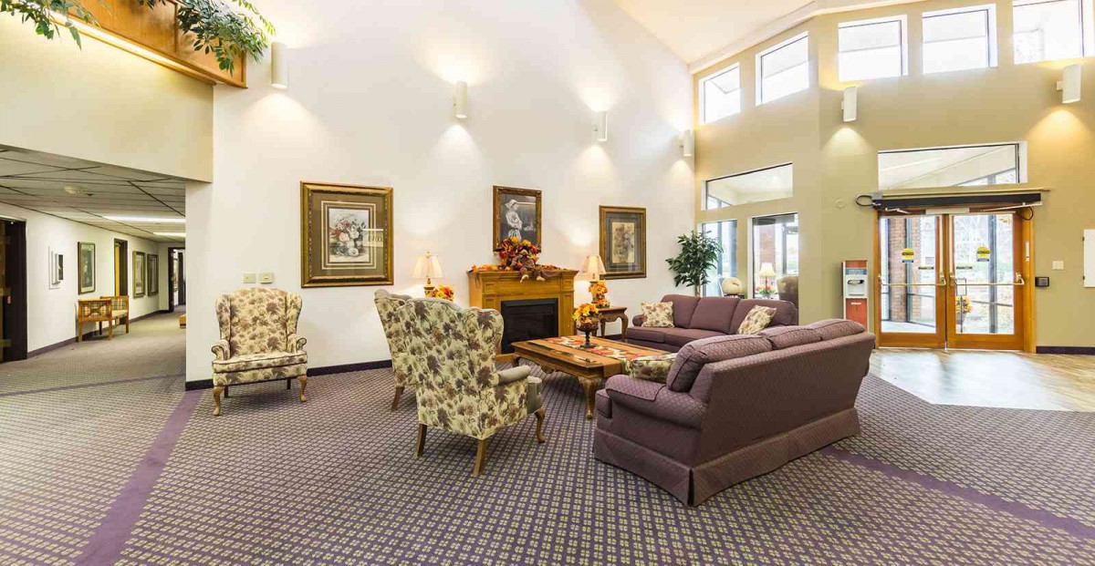 A cozy living room featuring a fireplace, elegant furniture, and decorative artwork.