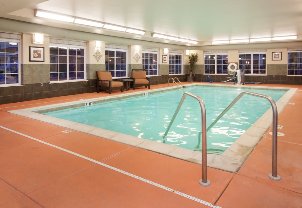 An inviting indoor swimming pool area with comfortable seating, perfect for relaxation.