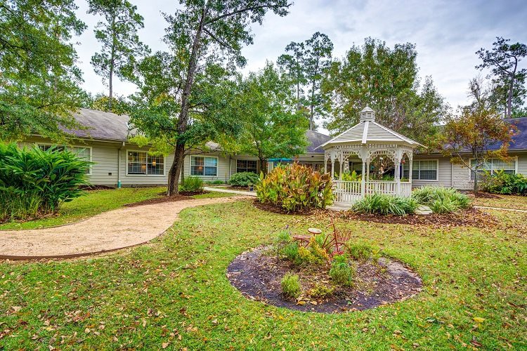 A serene garden with a gazebo, surrounded by lush greenery and a winding pathway.