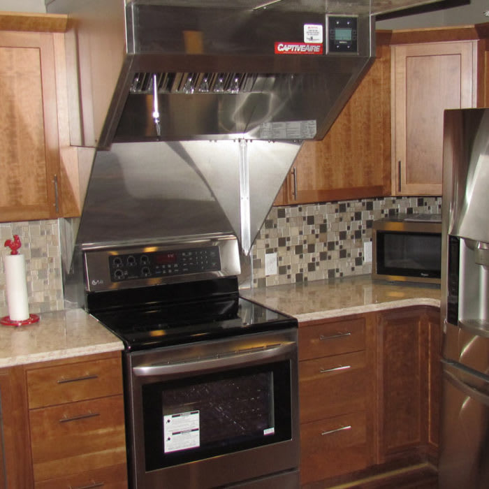 Modern kitchen with stainless steel appliances and wooden cabinets.