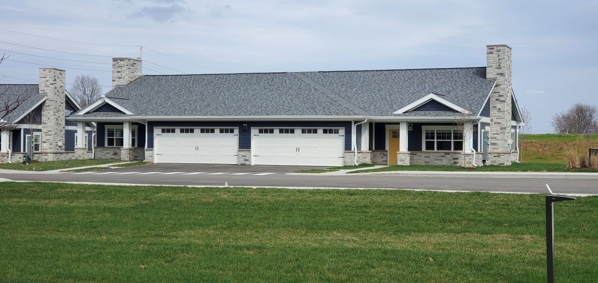 A modern residential house with a large garage and a well-maintained lawn.