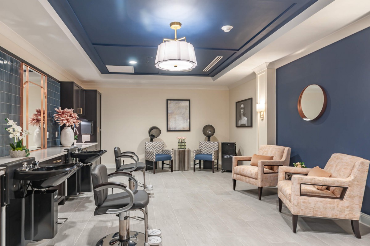 A modern salon interior with styling chairs, hair dryers, and a comfortable waiting area.
