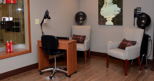 A cozy salon interior with a desk, chair, and hair dryer.