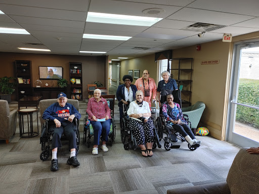 A diverse group of individuals seated in wheelchairs, gathered in a community space.
