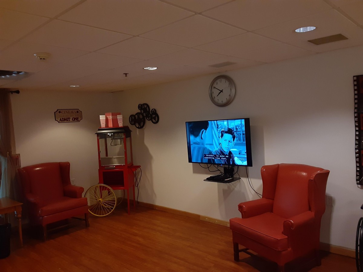 A cozy waiting room with armchairs, a television, and a popcorn machine.