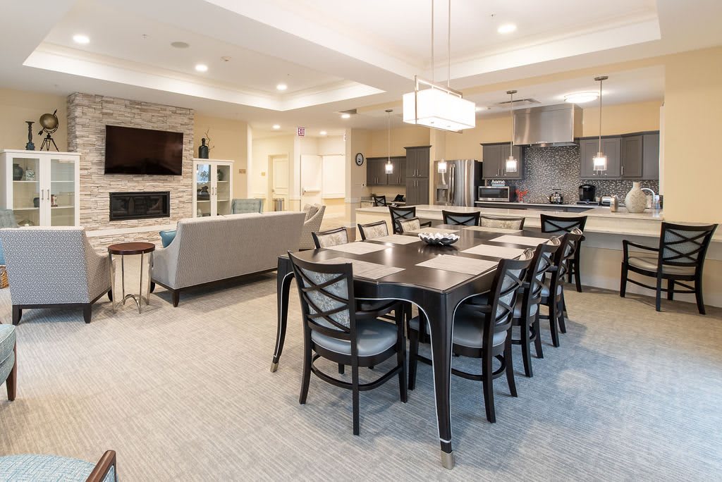 A modern open-plan living space featuring a dining area, kitchen, and seating in a contemporary interior.