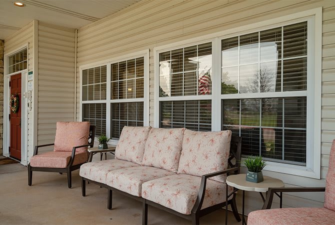 A cozy porch with cushioned seating and decorative plants.
