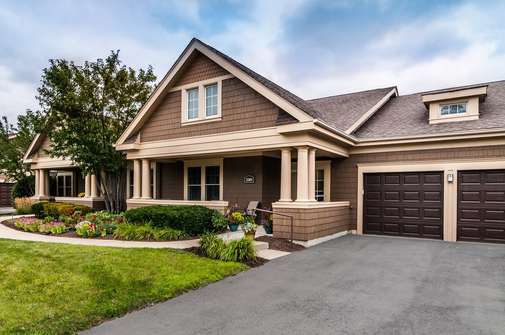 A beautiful suburban house with a porch and well-maintained front yard.
