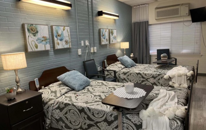 A well-organized hospital room with two beds, side tables, and decor.
