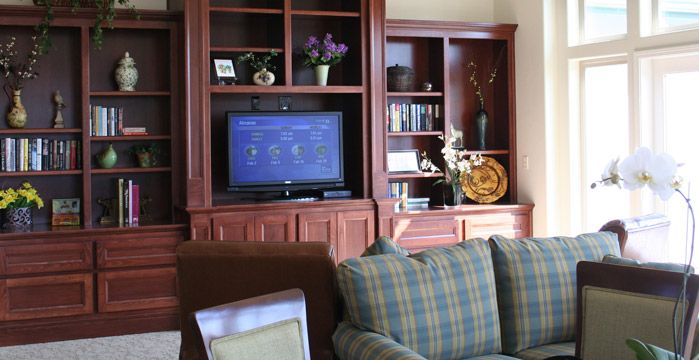 A cozy living room featuring an entertainment center with a TV, bookshelves, and a comfortable sofa.
