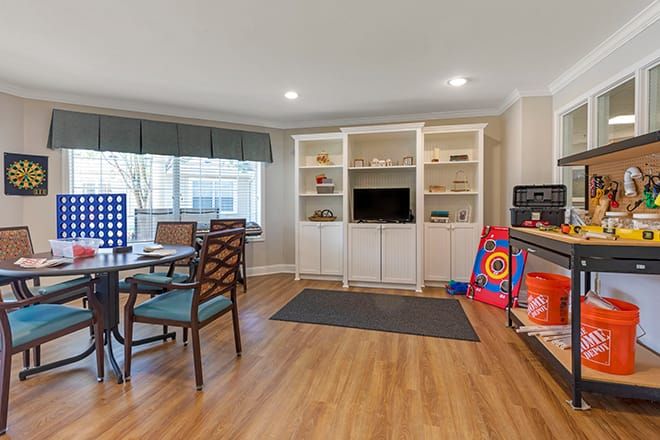 A cozy living room with built-in shelves, a TV, and a play area.