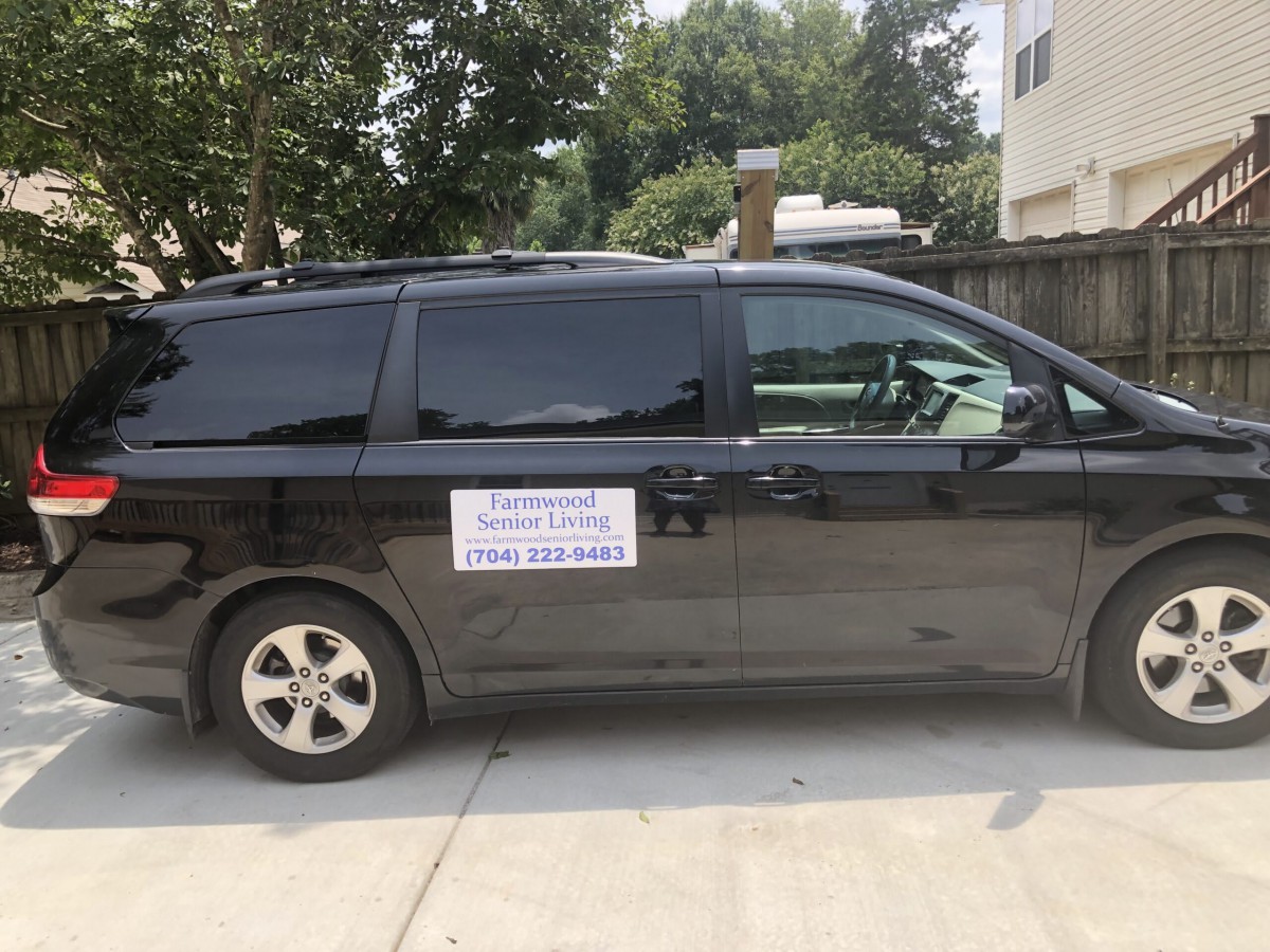 A black van with a sign on its side parked outdoors.