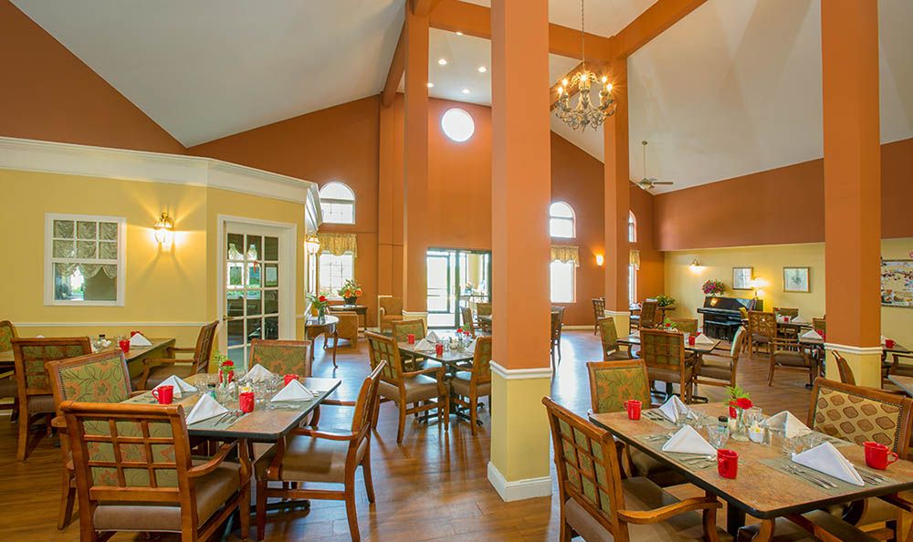 Elegant dining area with warm colors and a high ceiling.