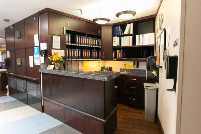 A well-organized office reception area with a desk and bookshelves.
