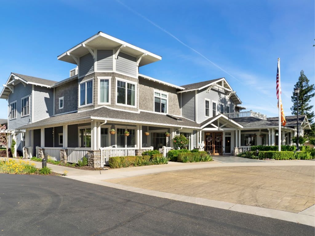 A modern residential building with a stylish architectural design and clear blue skies.
