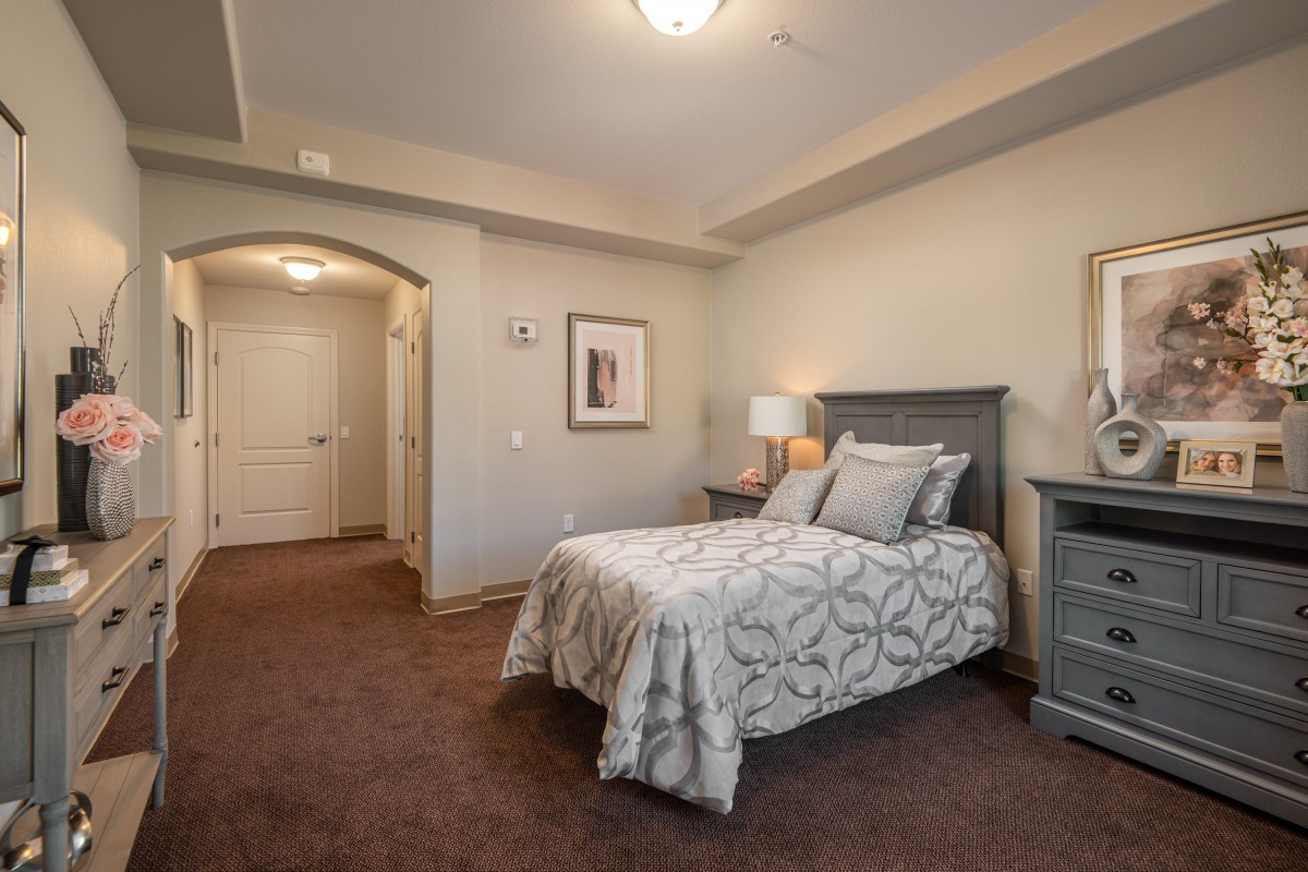 A cozy bedroom with a neatly arranged bed, side tables, and soft lighting.