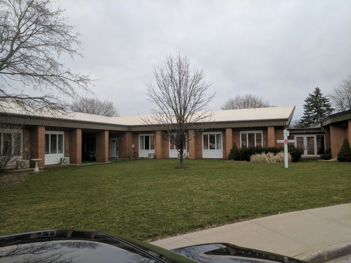 A suburban house with a well-maintained lawn and overcast sky.