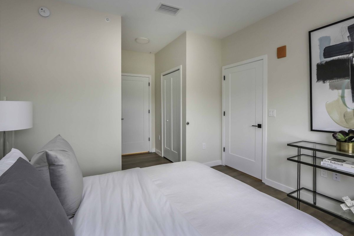 A minimalist bedroom with white walls and modern decor.
