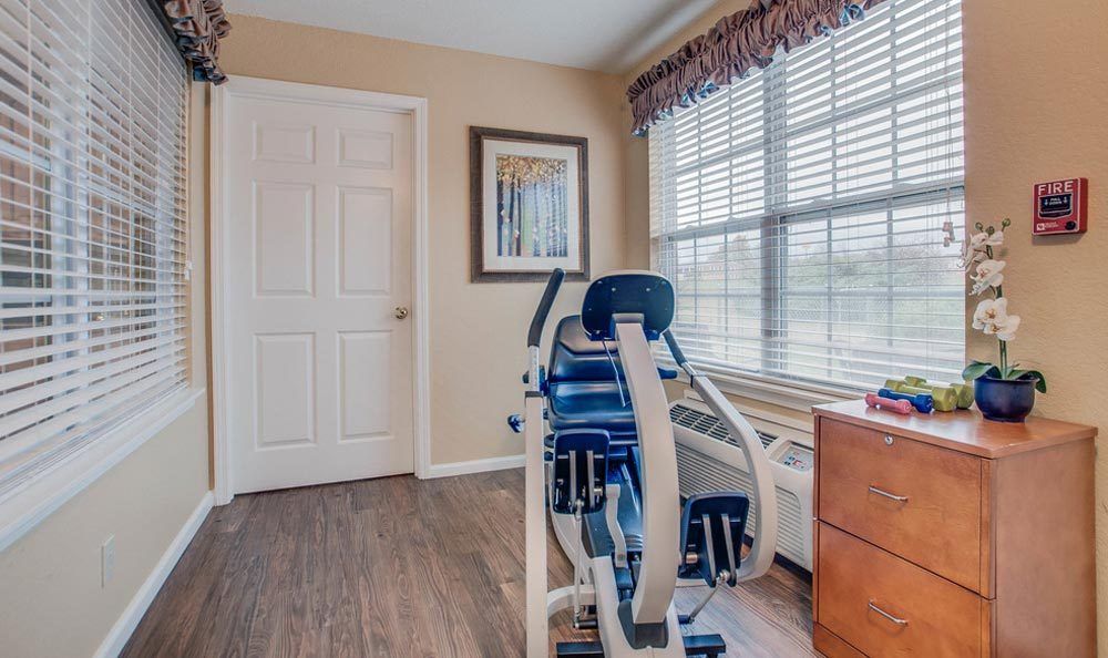 A small home gym with fitness equipment and a large window providing natural light.