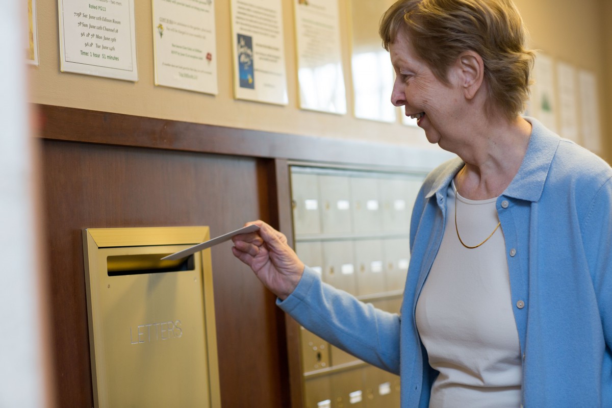 A woman mailing a letter at the post office.