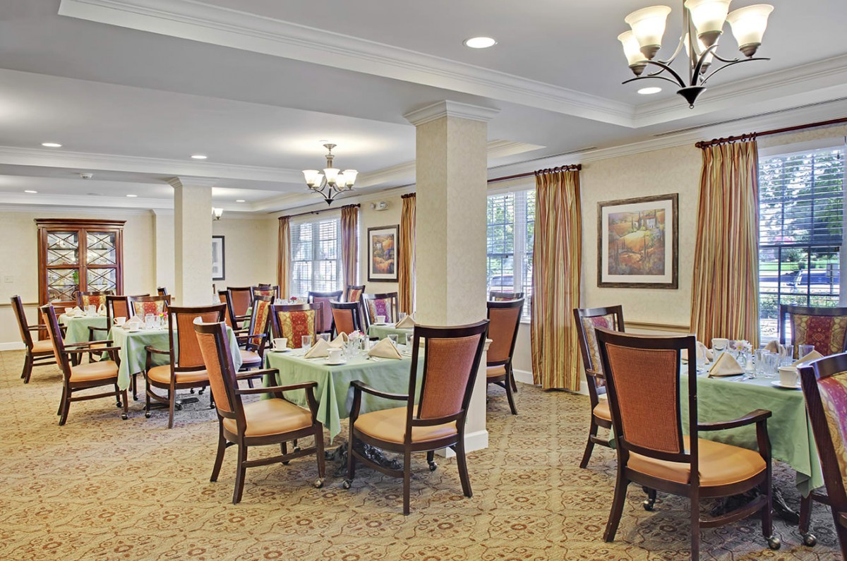 A well-lit dining area with neatly arranged tables and chairs.