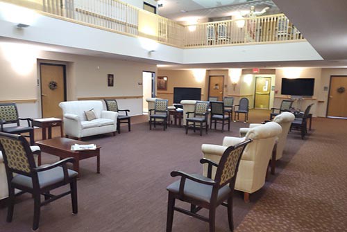 A spacious lobby with comfortable seating arranged for a meeting or gathering.