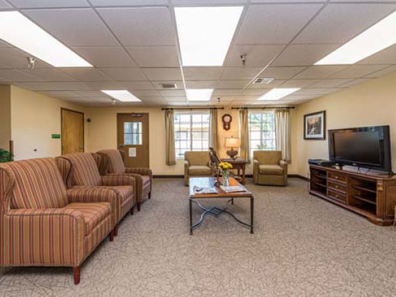 A cozy living room with comfortable seating, a television, and natural lighting.