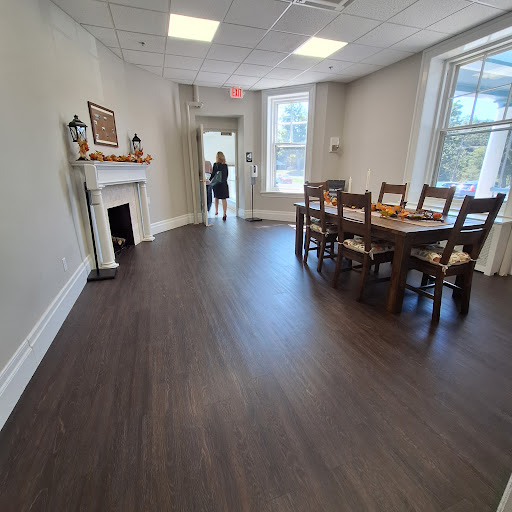 A spacious dining room with a wooden table, chairs, and a decorative fireplace.