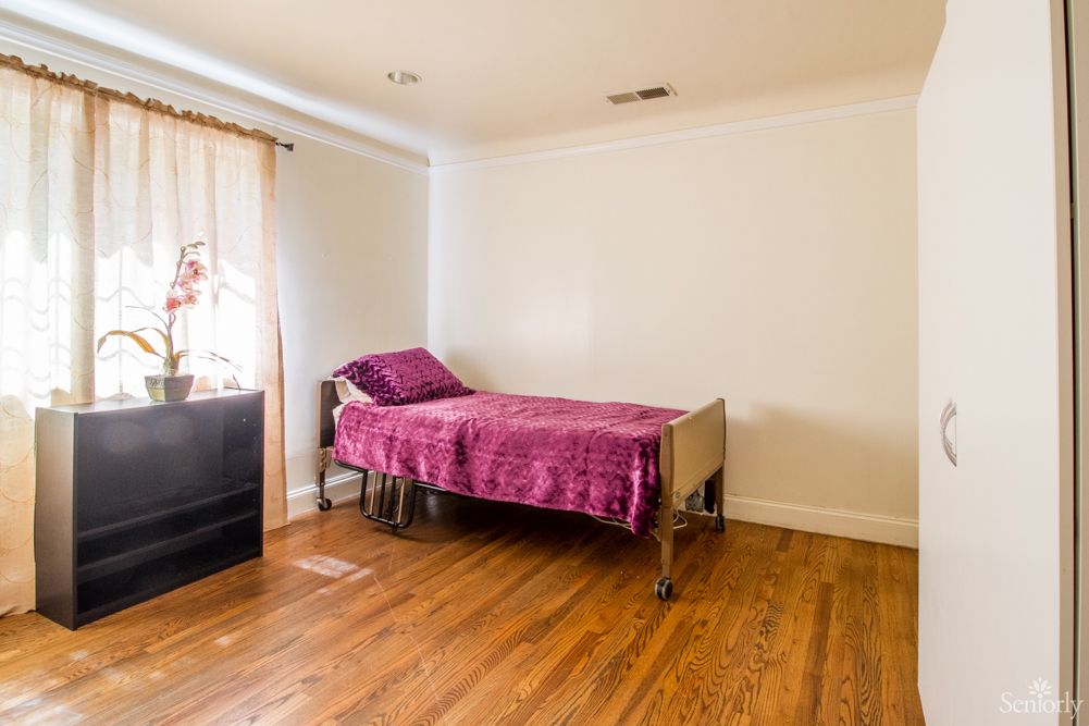 A minimalist bedroom with a single bed and wooden flooring.