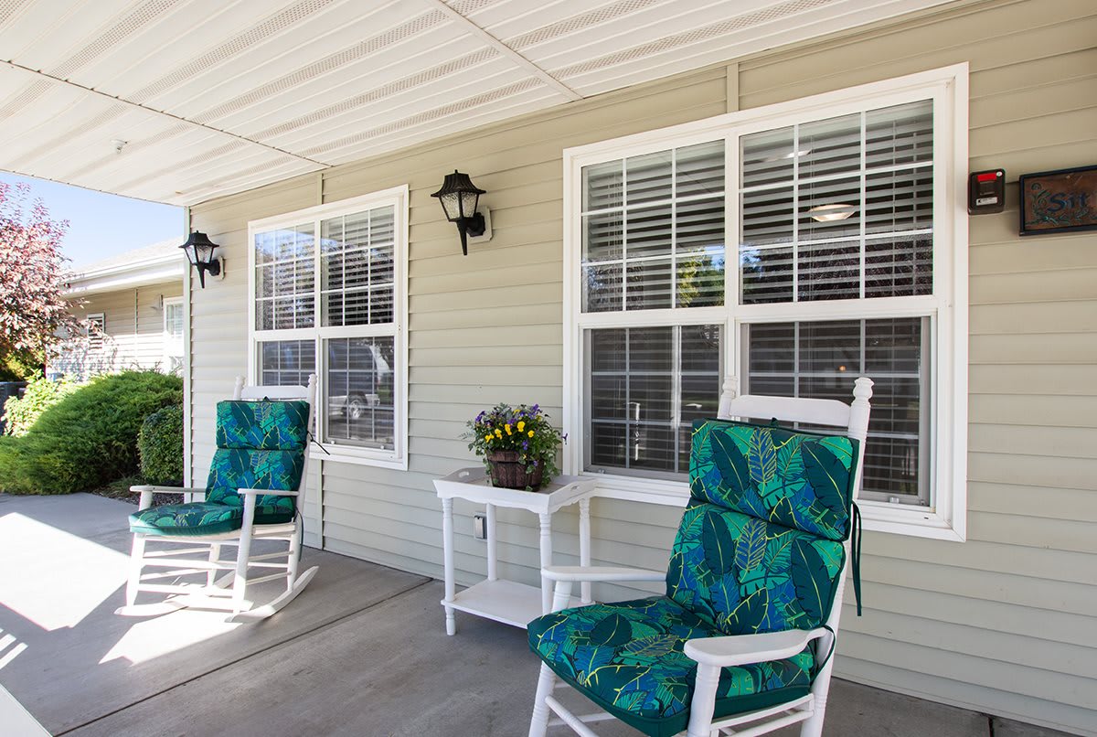 A cozy porch with rocking chairs and decorative cushions.
