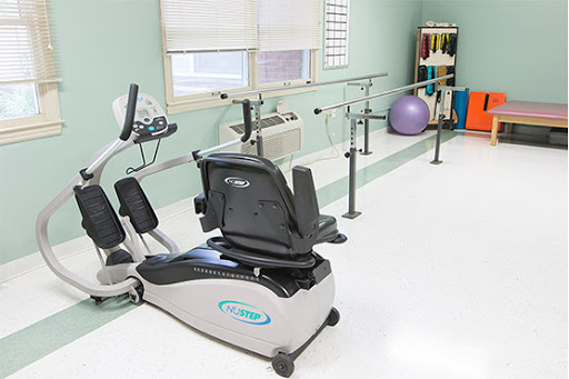A well-equipped physical therapy room featuring various exercise equipment for rehabilitation.
