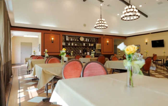 A cozy dining room with elegantly set tables and ambient lighting.