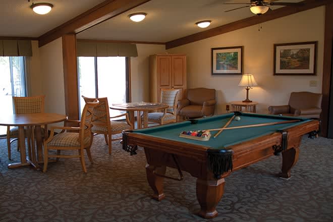 A cozy game room with a pool table and comfortable seating.