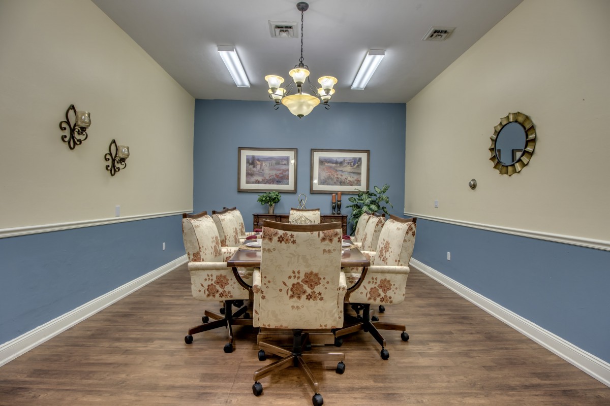 A well-decorated conference room with elegant chairs and a central table, featuring stylish lighting and wall art.