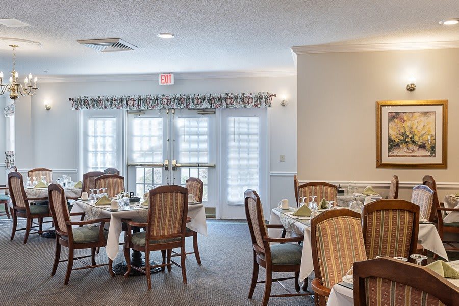 A dining room with elegantly set tables and chairs in a cozy indoor setting.