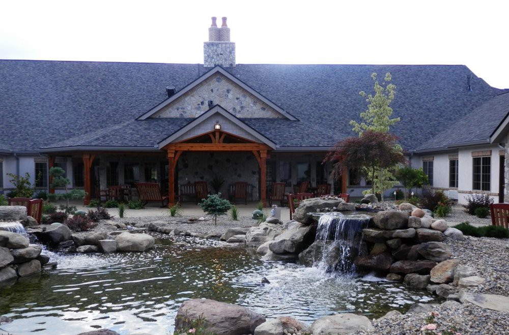 A picturesque building surrounded by a landscaped pond and waterfall.