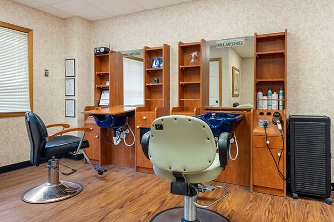 An interior view of a hair salon with styling stations and barber chairs.