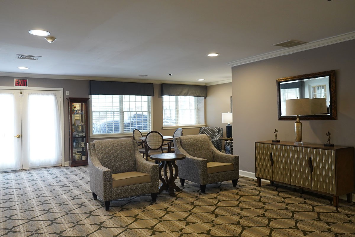 A cozy living room with armchairs and a decorative carpet.