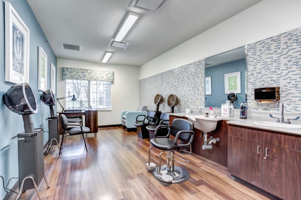 A clean and modern beauty salon with styling stations and equipment.