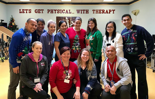 A joyful gathering of physical therapy professionals celebrating their teamwork and holiday spirit.
