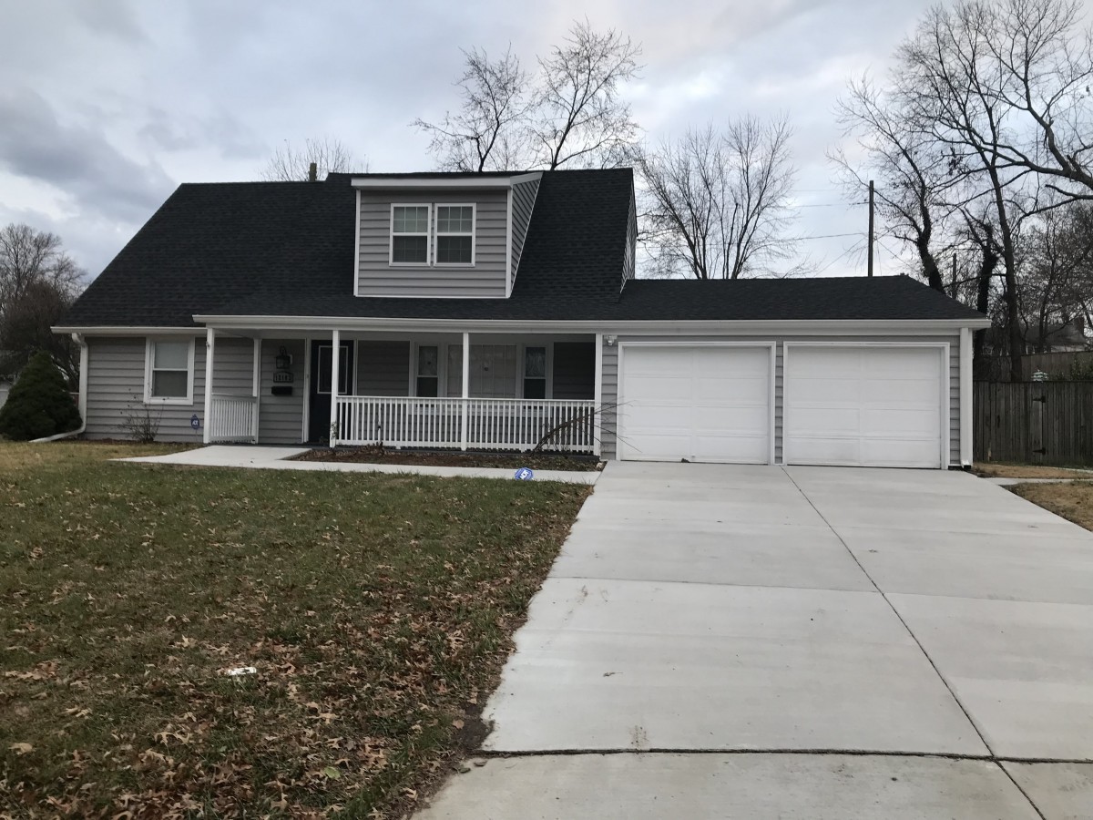 A suburban house with a two-car garage and a wide driveway.